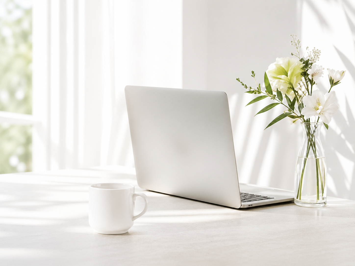 ノートPCと花のあるワークスペース